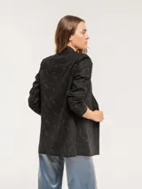 Blazer negro con bordado floral, de corte recto y largo a la cadera.