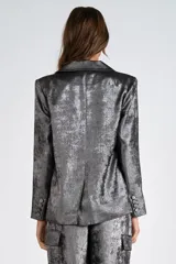 Blazer plateado de satén laminado, con cuello con solapa y abertura central con botón. Forro interno a tono.