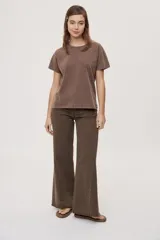 Pantalón jean de tiro medio, color negro, de corte amplio y silueta extra wide leg. Presenta diseño clásico de cinco bolsillos, cierre frontal con botón y cremallera, y detalle de tachas metálicas aplicadas a lo largo de los laterales.