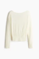 Top de punto fino transparente en color blanco, con mangas largas caídas, amplio escote bote y ribete acanalado ancho en la cintura y los puños.