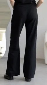 Pantalon de gamuza color marron, de corte recto y tiro medio, con cierre frontal y bolsillos laterales.
