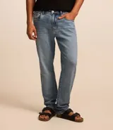 Pantalón de jeans denim celeste, corte slim, con cintura fija con trabillas, bolsillos y pespuntes.