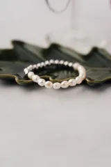 Pulsera elástica con cuentas de perlas de río y acero quirúrgico plateado.