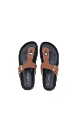 Sandalia tipo ojota con tira en forma de T, confeccionada en cuero sintético color marrón. Presenta una hebilla metálica dorada ajustable en el empeine y una suela de estilo corcho con base de goma negra.