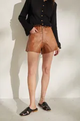Short de cuero sintético color marrón camel, de tiro alto y corte amplio.