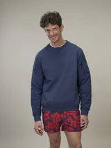 Sweater azul marino de cuello redondo y mangas largas con detalle acolchado en los hombros y bolsillo con cierre en la manga izquierda.