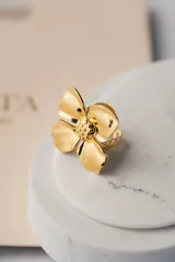 Anillo abierto dorado con forma de flor.