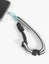 Llavero de cordón negro y blanco con mosquetón celeste.
