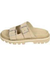 Sandalias de ante color beige con dos tiras anchas ajustables mediante hebillas metálicas plateadas. Presentan una suela de EVA gruesa y dentada de 5,3 cm de altura. Incluyen detalles distintivos de la marca Tommy Jeans en las hebillas y la plantilla.