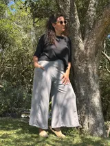 Conjunto compuesto por una blusa negra de corte holgado y mangas cortas, y un pantalón palazzo gris de tiro alto con faja ancha en la cintura y bolsillos laterales.