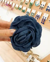 Broche de pelo azul marino con forma de rosa de tela.