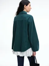 Camisa oversize de lyocell color tostado, con cuello clásico, cierre frontal de botones y mangas largas con puños anchos. Presenta un diseño de corte relajado con caída fluida.