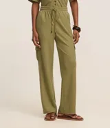Pantalón largo verde militar de corte fluido, con cintura elástica, cordón de ajuste y bolsillos cargo en los laterales.