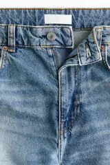 Jean de cinco bolsillos en denim de algodón rígido, con piernas maxivolumen de diseño curvo y corte estándar de cadera a muslo, ligeramente ceñidas en el bajo mediante trabilla. Cuenta con cintura de tiro alto, cierre y botón.