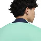 Remera deportiva Nike Dri-FIT Strike color verde agua con cuello alto azul marino y cierre de un cuarto. Logo de Nike estampado en blanco en el pecho.