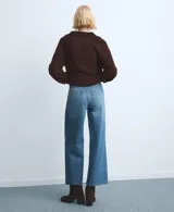 Jeans de denim azul de tiro medio, corte wide leg y diseño de pernera ancha con terminación deshilachada en el bajo.