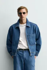 Cazadora de denim de algodón con cierre frontal de cremallera, cuello solapa y un bolsillo plastrón en el pecho. Presenta un diseño de corte regular con efecto lavado.