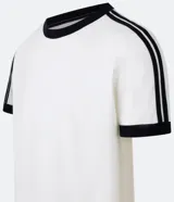 Remera de algodón color celeste con cuello redondo y bordes de mangas en color blanco. Presenta diseño de rayas dobles blancas en los hombros y mangas.