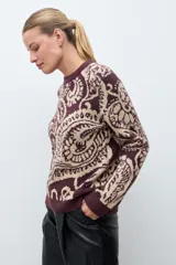 Sweater de punto con diseño jacquard de estilo paisley en tonos ciruela y beige, con cuello redondo y mangas largas.