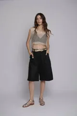 Bermuda blanca de lino, corte sastre, tiro alto, largo a la rodilla y bolsillos laterales.