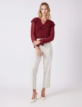 Pantalón sastrero color beige, de corte recto y tiro alto, con largo al tobillo. Tiene pretina limpia con cierre interno y pasadores, y bolsillos funcionales en la parte delantera.