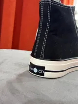 Zapatillas de lona color beige, tipo bota, con cordones marrones, puntera de goma y logo de peach engomado.