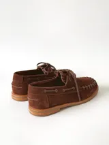 Sandalias de cuero gamuzado color marrón chocolate, diseño tipo huarache con tiras entrelazadas, tira en el empeine, talón cerrado y hebilla metálica de ajuste lateral.