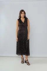 Vestido midi negro de lentejuelas con escote en V cruzado (cruzado tipo wrap) y breteles anchos. Presenta frunce en la cintura y tajo en la falda.