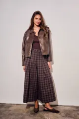 Pantalón de corte wide leg con diseño de cuadros, tiro medio y pinzas frontales que aportan volumen y movimiento a la prenda.