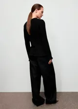 Cardigan entallado de tweed y lúrex color negro, con cuello redondo, manga larga, bolsillos de parche frontales y terminaciones deshilachadas. Cuenta con cierre delantero de botones metálicos.