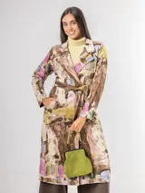 Trench de diseño urbano con acabado agamuzado, de corte recto y largo midi. Presenta un estampado abstracto multicolor con tonos rojizos, azules y ocres, cuello solapa, mangas largas y cinturón ajustable en la cintura.
