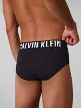Pack de tres slips Calvin Klein de algodón elástico en color negro. Presentan cintura elástica distintiva con el logo de la marca en diferentes colores: blanco, turquesa y negro.