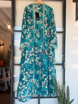 Kimono largo de tela estampada con motivos abstractos en tonos azules, verdes y beige. Diseño de manga ancha y corte recto, sin cierres.