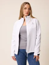 Campera softshell blanca con cierre frontal completo, cuello alto y bolsillos laterales. Presenta un bolsillo vertical con cierre en el pecho y el logo de la marca bordado.