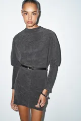 Vestido corto de tejido suave color gris oscuro, con cuello redondo y manga larga. Incluye un cinturón fino de efecto piel con hebilla metálica dorada.