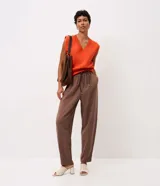 Pantalón carrot color marrón de modelado suelto en la cadera con barra afinada, cintura elástica con amarre ajustable y bolsillos.