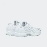 Championes Reebok Road Prime, color blanco con detalles en gris plateado. Presentan una parte superior de malla con paneles de tejido sintético y cuero, cierre con cordones, entresuela de EVA moldeada por inyección y suela de goma.