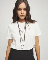 Collar de diseño triple compuesto por tres tiras de cuero marrón oscuro, cada una con un dije en forma de gota o esfera irregular con baño de plata.