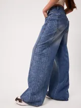 Jean wide leg de tiro alto color celeste, con diseño estampado tipo paisley en los laterales de las piernas.