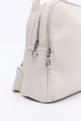 Mochila negra de cuero sintético texturizado, con doble compartimento principal con cierre metálico, bolsillos laterales y manija superior. Incluye correas regulables.