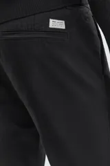Pantalón chino de corte ajustado, color beige, con bolsillos laterales y bolsillos traseros de vivo. Cuenta con cierre frontal de cremallera y botón.
