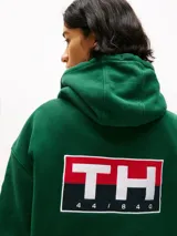 Buzo verde con capucha y cordón distintivo, bolsillo canguro, puños y bajo de punto canalé, logo oversize de Tommy Hilfiger en la manga y la parte trasera, parche con logo de Tommy Hilfiger en el pecho y detalles distintivos de Hilfiger Sailing.