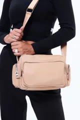 Bandolera negra de diseño moderno y funcional, confeccionada en cuero sintético. Cuenta con múltiples bolsillos externos con cierre, compartimento principal amplio y correa regulable para llevar al hombro o cruzada.