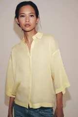 Camisa de cuello solapa y manga larga amplia de la colección ZW Collection de Zara, con cierre frontal de botones ocultos por solapa.