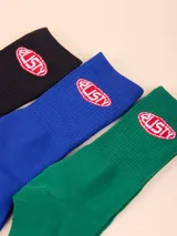 Pack de tres pares de medias de caña media, en color negro, azul y verde. Cada par presenta el logo de la marca Rusty bordado en el lateral.