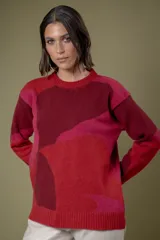 Buzo de lana con cuello redondo y diseño abstracto que simula un paisaje, en tonos rojos, fucsias y bordó. Presenta puños y ruedo acanalados.