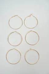 Aros tipo argolla de diseño circular clásico en tono dorado, con cierre de gancho integrado.
