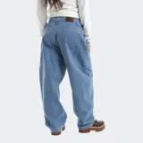 Pantalón de jean estilo baggy con corte barrel, color negro, con bolsillos laterales y logo bordado tono sobre tono.