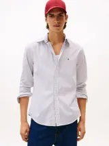 Camisa de popelín de puro algodón de corte regular, con diseño de rayas finas, cuello clásico, mangas largas con puños abotonados y el logo de la marca bordado en el pecho.