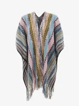 Capa o poncho de tejido de punto con diseño de zigzag multicolor, con cuello en V y flecos largos en el borde inferior.